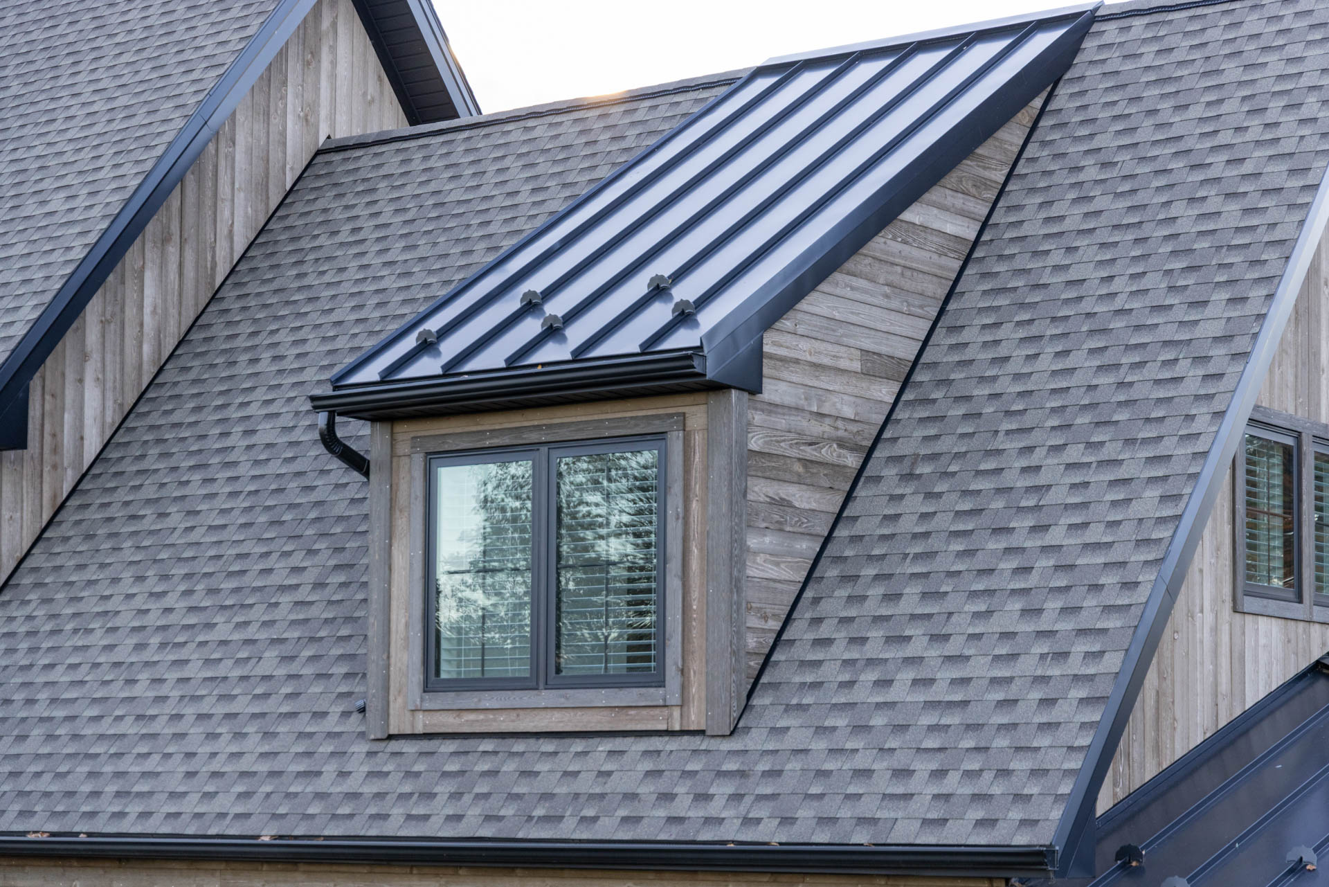 Upper-level dormer featuring 1x6 Homestead Ship Lap siding against a dark metal roof.