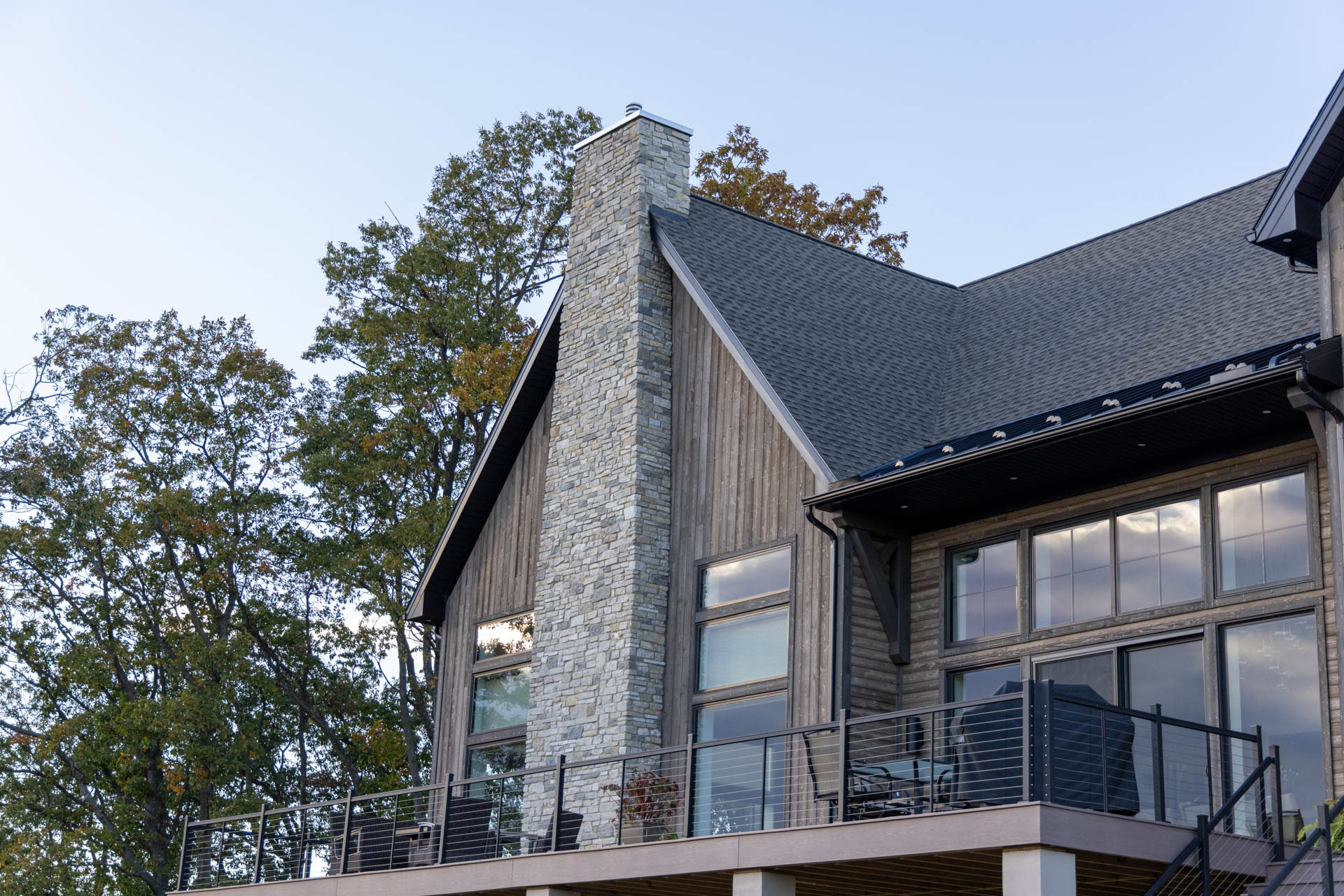 Full-length natural stone chimney intersecting with Western Red Cedar Ship Lap siding.