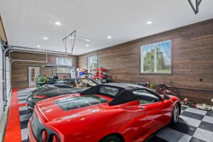 A red Ferrari parked in a luxury garage featuring continuous ranchwood Eastern cedar siding on the interior walls.