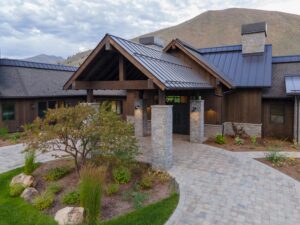 The grand entrance of a luxury contemporary mountain estate featuring custom ranchwood Western Douglas Fir siding and heavy timber framing.
