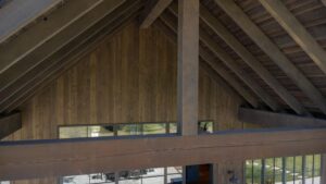Close-up of massive structural 10x18 Douglas Fir timber beams finished in ranchwood Western on a covered luxury patio.