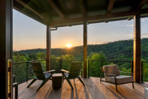Covered outdoor balcony with Thermally Modified Southern Yellow Pine wood decking and timber posts overlooking a mountain sunset at Casa Bonita 2.