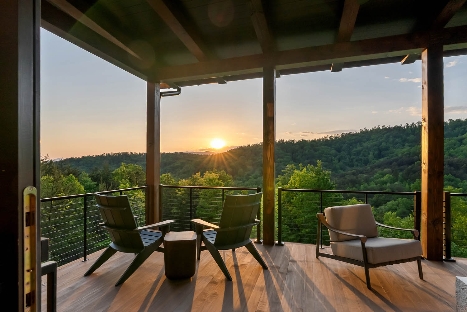 Covered outdoor balcony with Thermally Modified Southern Yellow Pine wood decking and timber posts overlooking a mountain sunset at Casa Bonita 2.