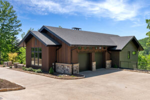 Garage facade and driveway at Casa Bonita 2 clad in vertical thermally modified Southern Yellow Pine wood siding.