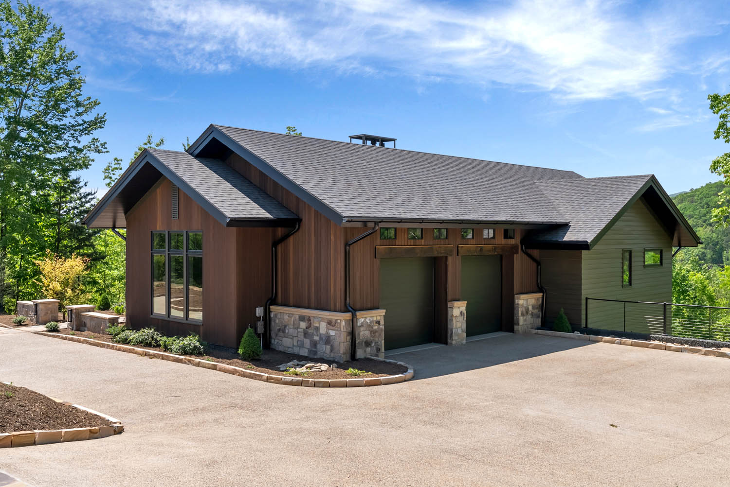 Garage facade and driveway at Casa Bonita 2 clad in vertical thermally modified Southern Yellow Pine wood siding.