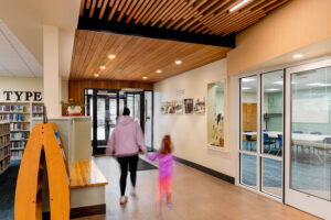 Interior entry hallway showing smooth AquaFir Light Brown wood ceiling panels continuing from the exterior entry soffit.